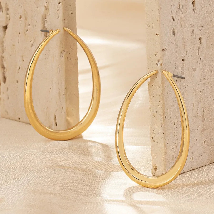 Aretes leuce dorados sobre fondo beige y marmol.jpg